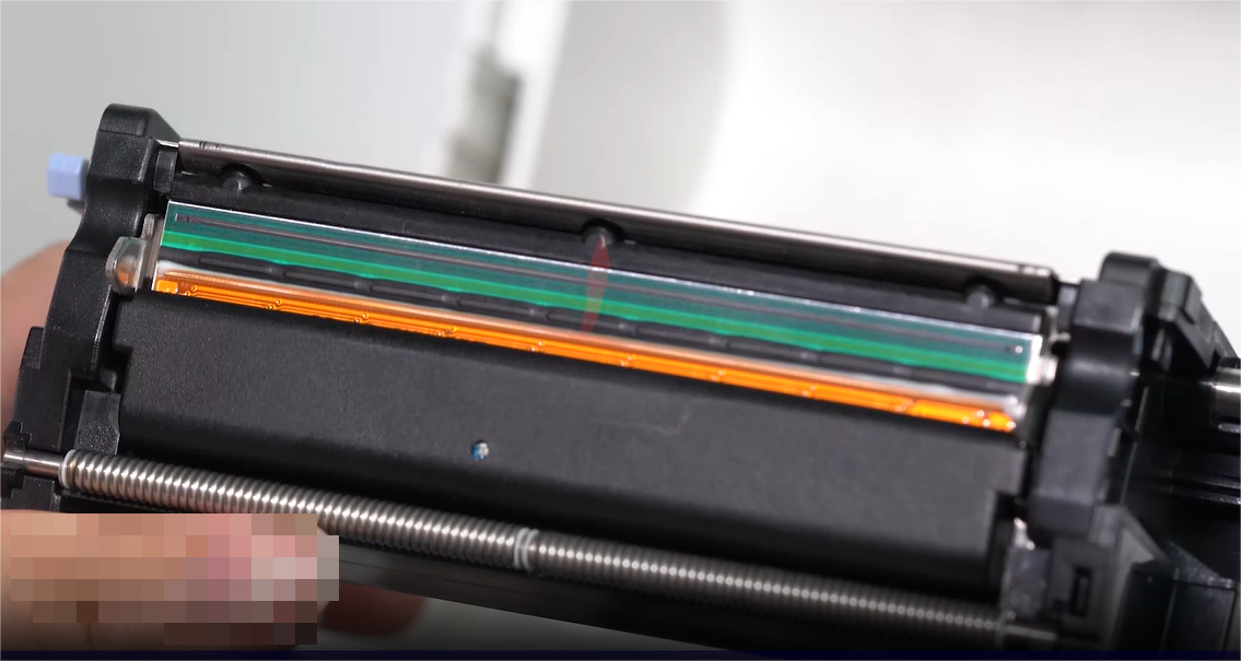 A close-up of a person carefully cleaning an electronic component with a swab.